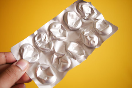 Close up of hand holding blister packs .