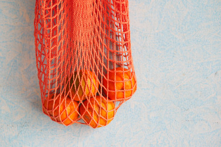 fresh orange fruit in a shopping bag on tableの写真素材