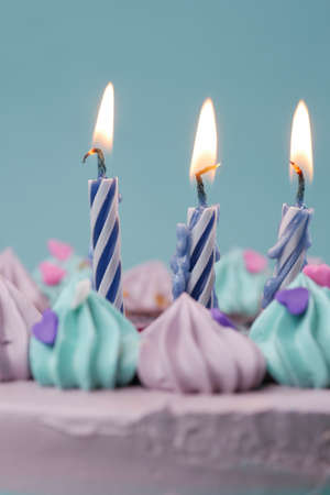 slow motion of burning candle on a birthday cake on light purple backgroundの写真素材