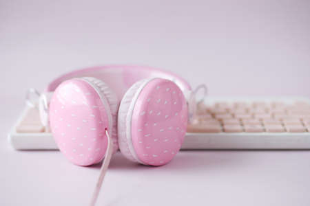 pink color headphone on keyboard on pink .の写真素材