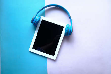 Audio book concept. Headphones and digital tablet on tableの写真素材