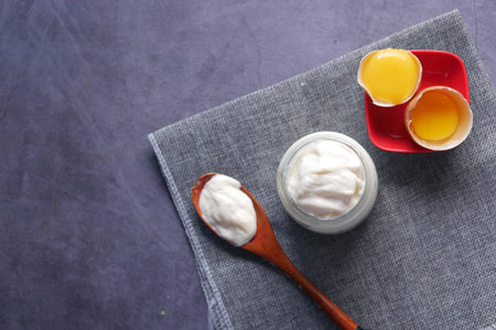 Mayonnaise in container , oil and eggs on tableの写真素材