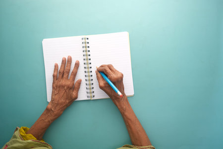 top view of senior woman hand on blank paper on table