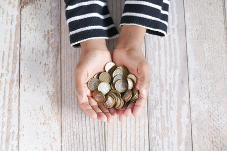 teenage boy hand hold a saving coins top view