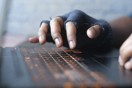hacker hand stealing data from laptop top downの写真素材
