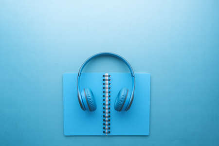 Audio book concept. Headphones and notepad on white backgroundの写真素材
