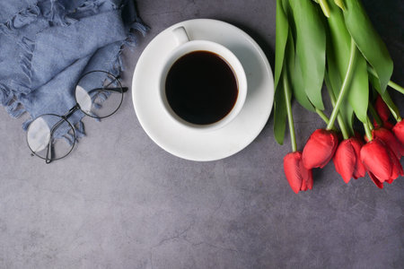 flat composition coffee, tulip flower and eyeglass on black background .の写真素材
