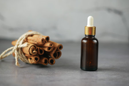 cinnamon essential oil in a container on tableの写真素材