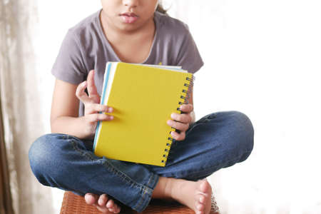 teenage child holding many colorful notepadsの写真素材