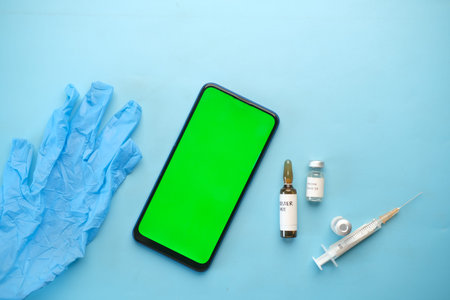 top view of coronavirus vaccine , syringe and smart phone on table