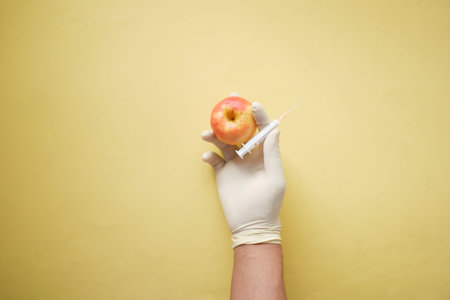 doctors hand holding green apple on yellow background