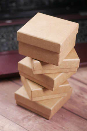 stack of cardboard parcels and laptop on tableの写真素材