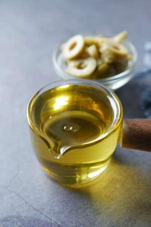 olive oil and fresh olive in a container on table .の写真素材