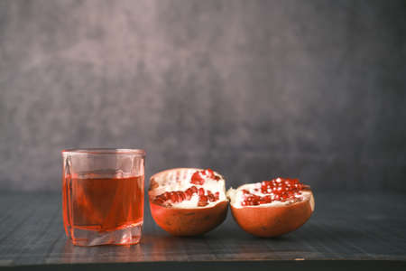 glass on pomegranate juice on black background .の写真素材