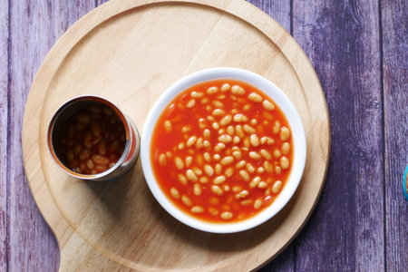 Tasty baked beans in a bowl on orange background ,