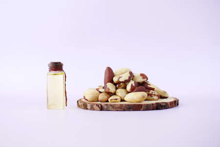 brazilian nut dropping in a bowl and oil in a small bottleの写真素材