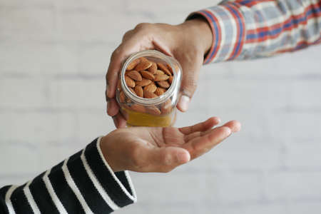 close up of almond nuts on mans handの写真素材