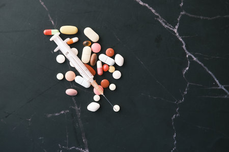 syringe and pills on dark background, close upの写真素材