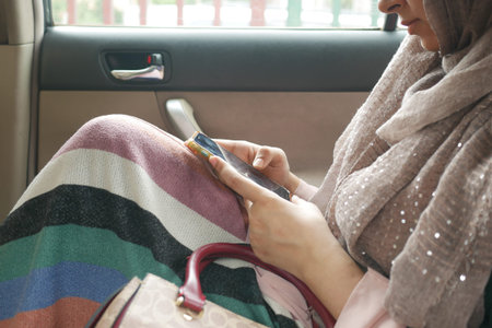women hand holding smart phone in a car