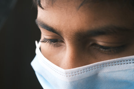 teenage boy with protective face mask looking down