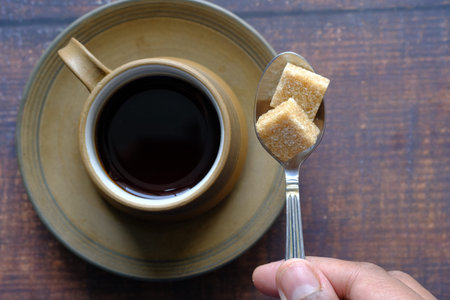 cup of tea and sugar cube on tableの写真素材