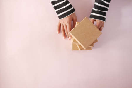 hand hold homemade gift box on color backgroundの写真素材
