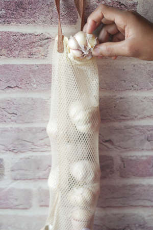 putting garlic in a reusable bagの写真素材