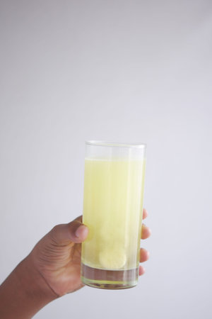 holding a glass of water with Effervescent soluble tablet pills