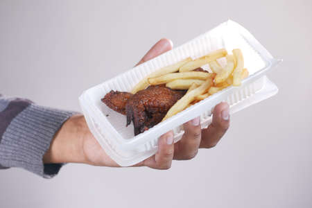 Crispy fried chicken wings and fries in a take away packet .の写真素材