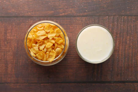 Top view of corn flakes and glass of milk on tableの写真素材