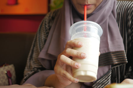 young women drinking banana milk shake at cafe