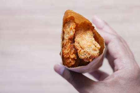 Crispy fried chicken wings in a paper packetの写真素材