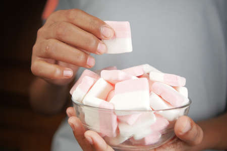 eating marshmallow candy in a bowlの写真素材