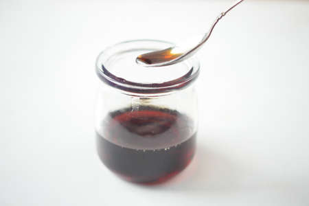 maple syrup in a small glass jar on tableの写真素材