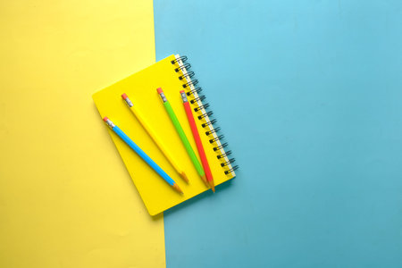 high angle view of color notepad and pencils on color backgroundの写真素材