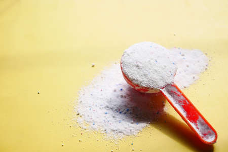Washing powder in plastic spoon on blue backgroundの写真素材