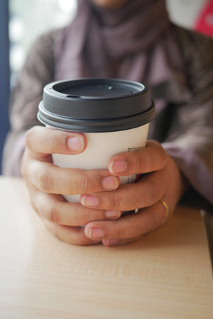 women holding a take away paper coffee cupの写真素材