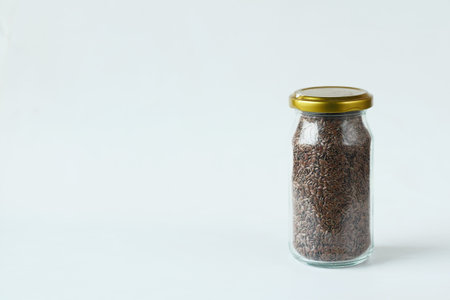 flax seeds in a glass jar on white backgroundの写真素材