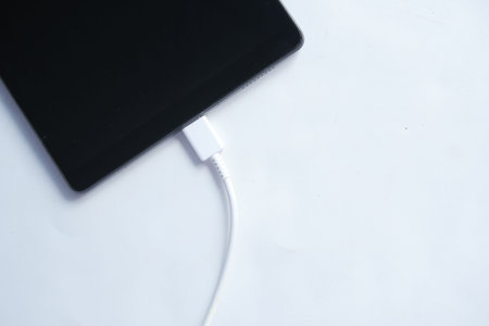 charging s digital tablet with a cable on white background