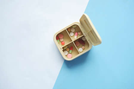 top view of medical pills in a pill box on tableの写真素材