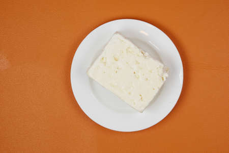 feta cheese on a plate on orange backgroundの写真素材