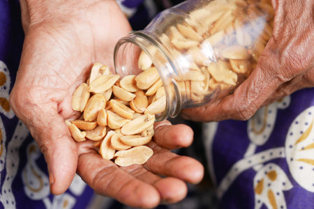 senior women pouring peanuts on hand