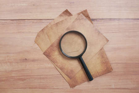 empty old paper and magnifying glass on table.の写真素材