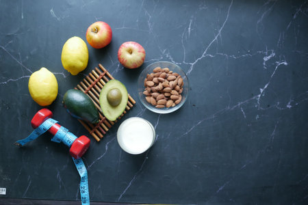mixed nut in a bowl, milk and dumbbell on tableの写真素材