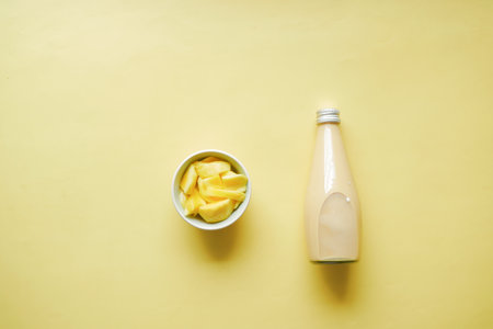 mango smoothie and fresh mango on yellow backgroundの写真素材