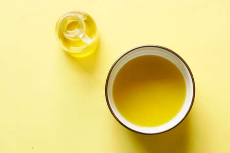 olive oils in a bowl on yellow backgroundの写真素材