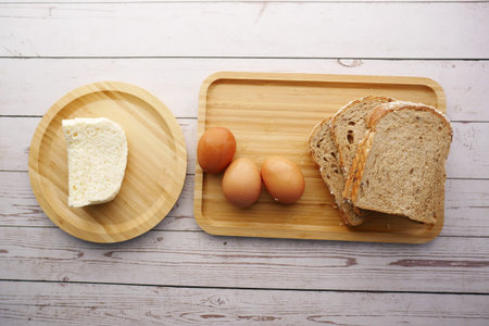 top view of cheese, egg, brown bread on table