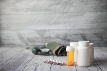 blood pressure machine and medical pill on table .