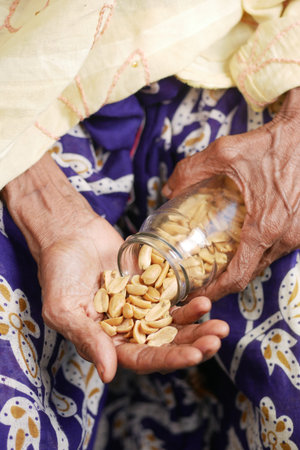 senior women eating peanuts close up