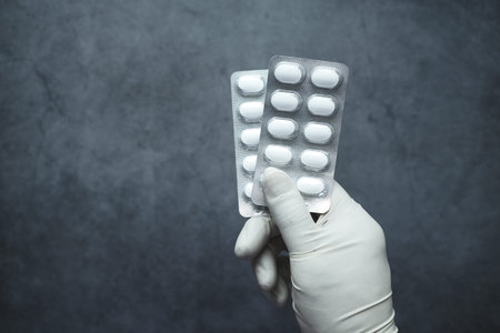 doctor hand in gloves holding blister pack